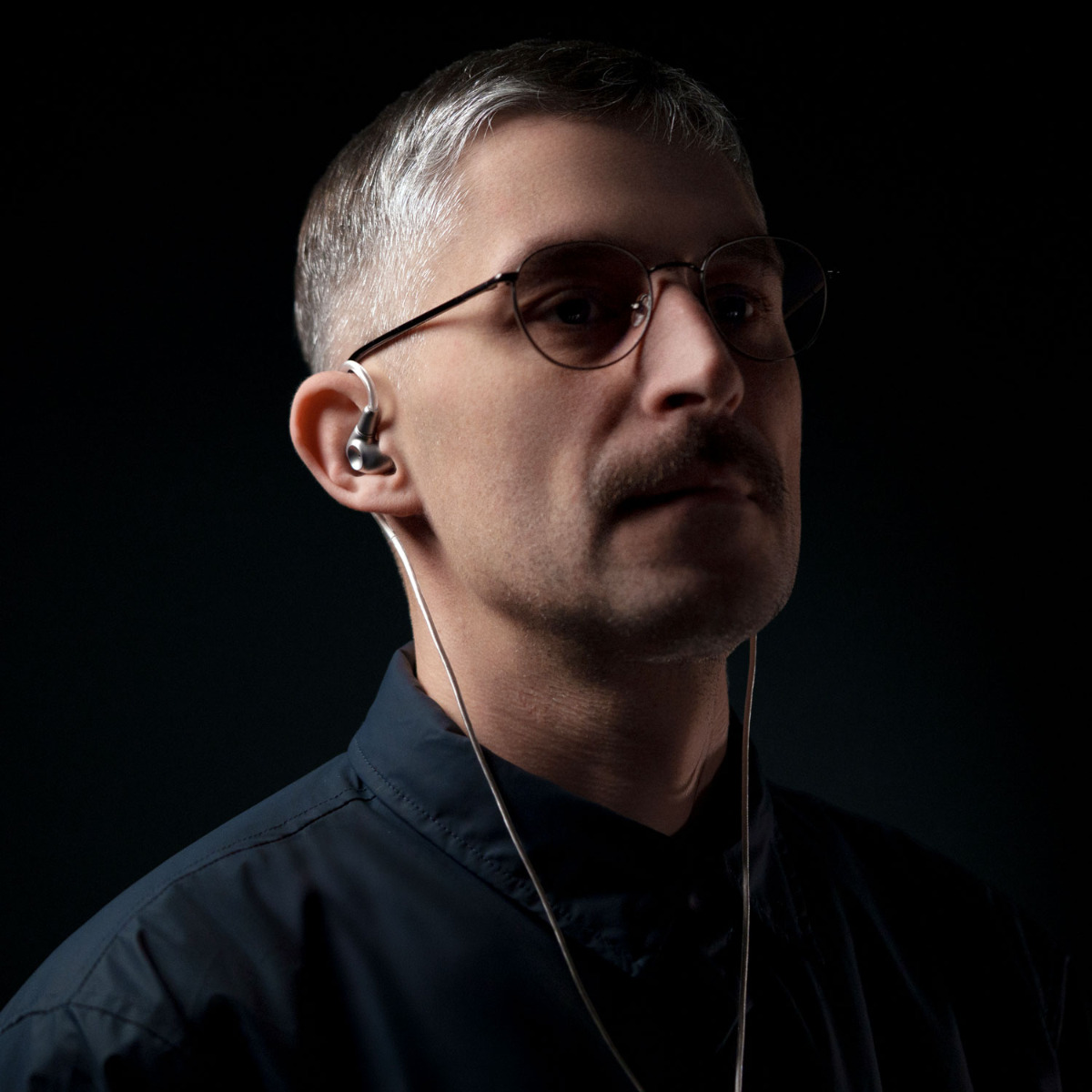 Älterer Herr, der mit den MEZE Audio Astru Musik hört.